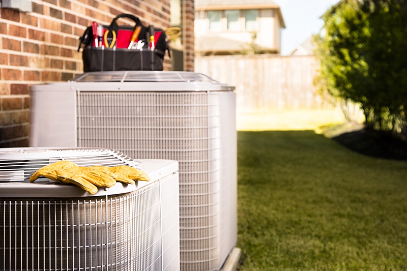 Bag of repairman's work tools on top of an air conditioner