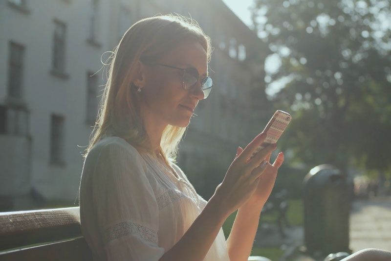 Image of person looking at their phone. Video - Are Wi-Fi Thermostats Cost-Effective?